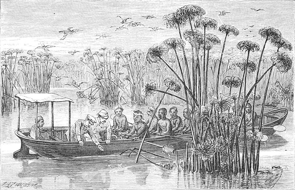 Die Expeditionsteilnehmer   sitzen in einem Ruderboot auf einem Fluss