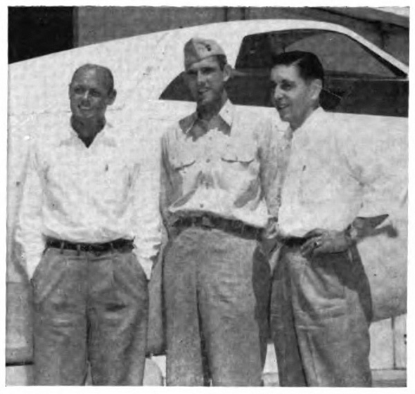 Three men standing in front of a plan