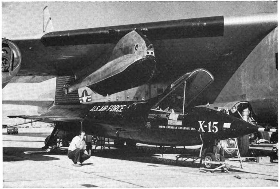 A crew working on a small plane standin on the ground next to a larger plane