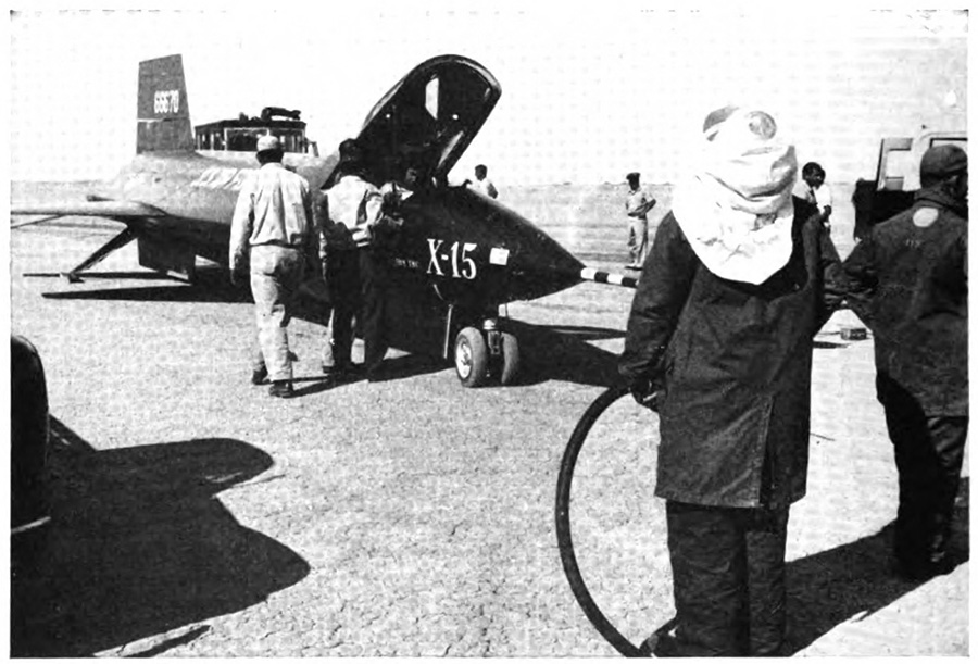A person walking up to a plane on the ground with its cockpit open