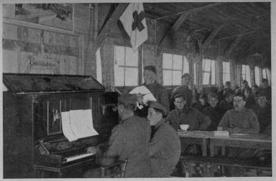 TICKLING THE OLD IVORIES
Many an ancient piano did herculean service in the A. R. C. recreation huts throughout France