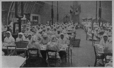 BANDAGES BY THE TENS OF THOUSANDS
An atelier workshop of the A. R. C. in the Rue St. Didier, Paris, daily turned out surgical dressings by the mile
